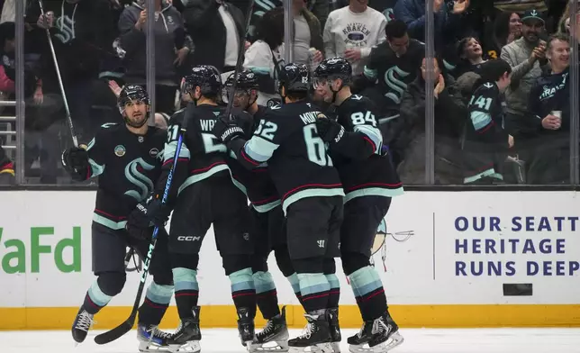 Seattle Kraken center Matty Beniers, left, celebrates his goal against the Vancouver Canucks with teammates during the third period of an NHL hockey game Thursday, Jan. 2, 2025, in Seattle. (AP Photo/Lindsey Wasson)