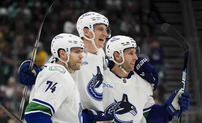 Vancouver Canucks defenseman Tyler Myers, center, celebrates his goal with left wing Jake DeBrusk (74) and defenseman Guillaume Brisebois, right, during the third period of an NHL hockey game against the Seattle Kraken, Thursday, Jan. 2, 2025, in Seattle. (AP Photo/Lindsey Wasson)