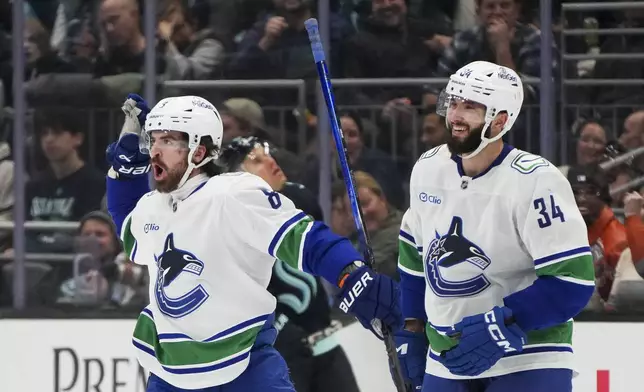 Vancouver Canucks right wing Conor Garland celebrates his goal against the Seattle Kraken with left wing Phillip Di Giuseppe (34) during the second period of an NHL hockey game Thursday, Jan. 2, 2025, in Seattle. (AP Photo/Lindsey Wasson)