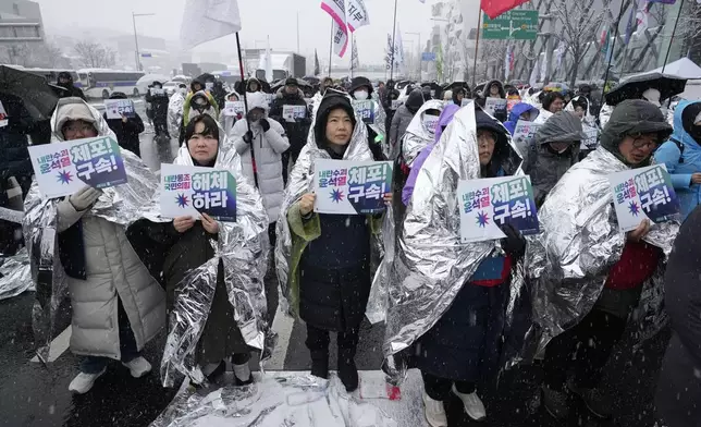 Protesters attend a rally demanding the arrest of impeached South Korean President Yoon Suk Yeol near the presidential residence in Seoul, South Korea, Sunday, Jan. 5, 2025. Banners read "Disband the ruling People Power Party," second left, and "Arrest Yoon Suk Yeol." (AP Photo/Ahn Young-joon)