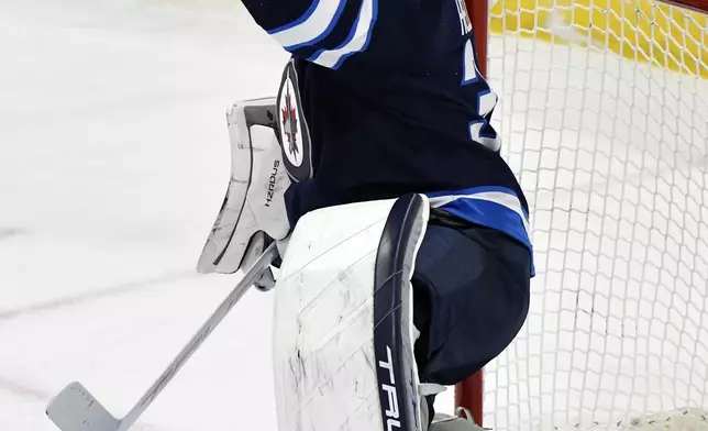 Winnipeg Jets goaltender Connor Hellebuyck (37) makes a save on a Nashville Predators shot during the first period of an NHL hockey game in Winnipeg, Manitoba, Tuesday, Jan. 7, 2025. (Fred Greenslade/The Canadian Press via AP)