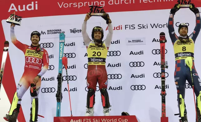 Bulgaria's Albert Popov, center, winner of an alpine ski, men's World Cup slalom, poses on podium with second placed Switzerland's Loic Meillard, left, and third placed Croatia's Samuel Kolega, in Madonna di Campiglio, Italy, Wednesday, Jan.8, 2025. (AP Photo/Alessandro Trovati)