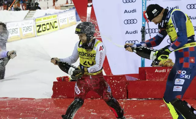 Bulgaria's Albert Popov sprays sparkling wine as he celebrates on podium winning an alpine ski, men's World Cup slalom in Madonna di Campiglio, Italy, Wednesday, Jan.8, 2025. (AP Photo/Alessandro Trovati)