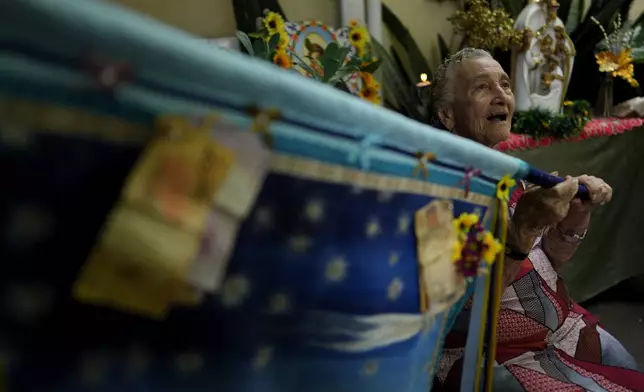 Matriarch Terezinha de Jesus, sings prayer hymns to the Holy Kings during Santo Antonio Folia de Reis group procession marking Epiphany, or Three Kings Day, in Santo Antonio de Goias, Brazil, Saturday, Jan. 4, 2025. (AP Photo/Eraldo Peres)