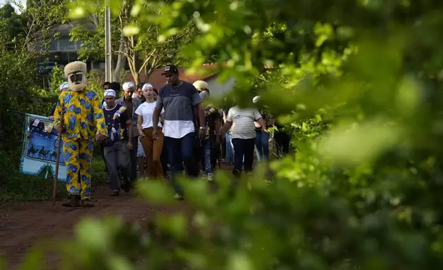 Performers of the Santo Antonio Folia de Reis group arrive at a procession marking Epiphany, or Three Kings Day, in Santo Antonio de Goias, Brazil, Sunday, Jan. 5, 2025. (AP Photo/Eraldo Peres)