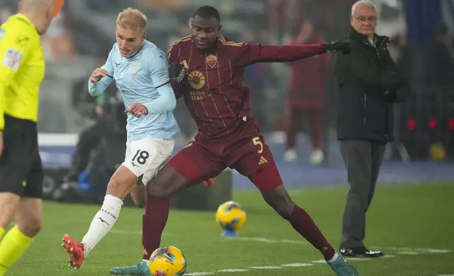 Roma's Evan Ndicka, right, duels for the ball with Lazio's Gustav Isaksen during a Serie A soccer match between Roma and Lazio, at the Stadio Olimpico in Rome, Italy, Sunday, Jan. 5, 2025. (AP Photo/Alessandra Tarantino)