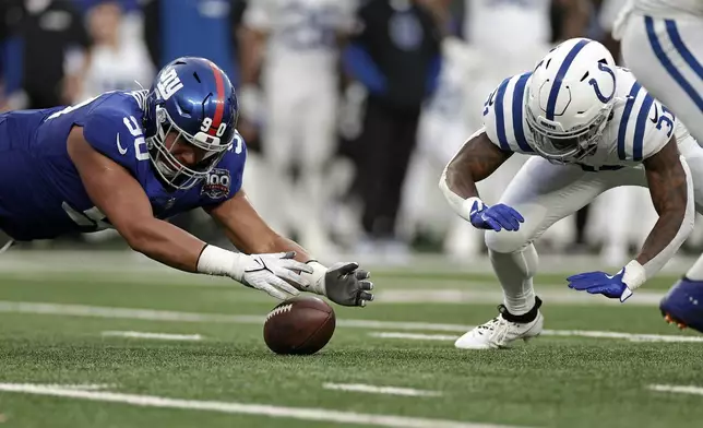 New York Giants defensive end Elijah Garcia (90) recovers a fumble in front of Indianapolis Colts running back Tyler Goodson (31) during an NFL football game Sunday, Dec. 29, 2024, in East Rutherford, N.J. (AP Photo/Adam Hunger)