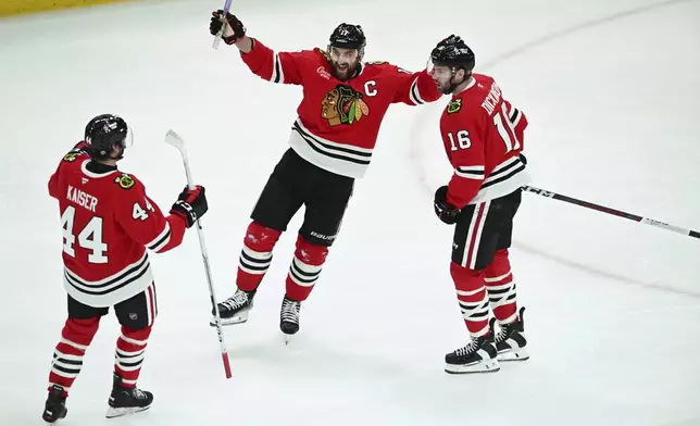 Chicago Blackhawks' Nick Foligno (17) celebrates with teammates Wyatt Kaiser (44) and Jason Dickinson (16) after scoring a goal during the second period of an NHL hockey game against the Montreal Canadiens, Jan. 3, 2025, in Chicago. (AP Photo/Paul Beaty)