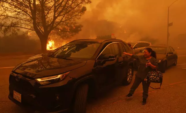 A woman cries as the Palisades Fire advances in the Pacific Palisades neighborhood of Los Angeles Tuesday, Jan. 7, 2025. (AP Photo/Etienne Laurent)