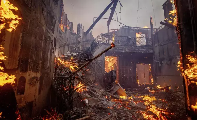 The Palisades Fire burns a residence in the Pacific Palisades neighborhood of Los Angeles, Tuesday, Jan. 7, 2025. (AP Photo/Etienne Laurent)