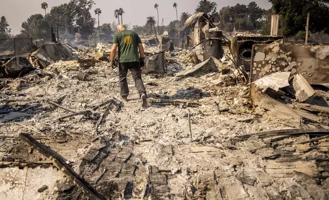 FILE - Marvin Meador walks on the remains of his fire-ravaged property after the Mountain Fire swept through, Nov. 7, 2024, in Camarillo, Calif. (AP Photo/Ethan Swope, File)