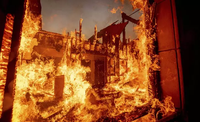 The Palisades Fire burns a residence in the Pacific Palisades neighborhood of Los Angeles, Tuesday, Jan. 7, 2025. (AP Photo/Ethan Swope)