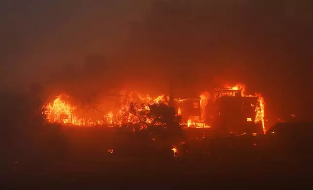 The Palisades Fire burns a property in the Pacific Palisades neighborhood of Los Angeles, Tuesday, Jan. 7, 2025. (AP Photo/Etienne Laurent)