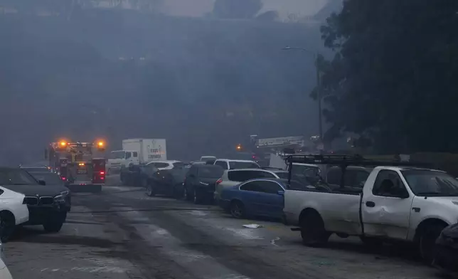 Vehicles are left stranded off the side of the road after residents tried to flee from the Palisades Fire in the Pacific Palisades neighborhood of Los Angeles, Tuesday, Jan. 7, 2025. (AP Photo/Etienne Laurent)