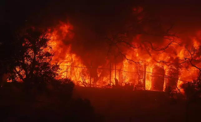 The Palisades Fire burns a property in the Pacific Palisades neighborhood of Los Angeles, Tuesday, Jan. 7, 2025. (AP Photo/Etienne Laurent)