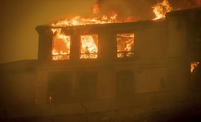 A residence burns as the Palisades Fire advances in the Pacific Palisades neighborhood of Los Angeles, Tuesday, Jan. 7, 2025. (AP Photo/Ethan Swope)