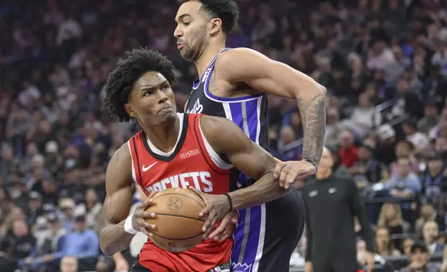 Houston Rockets forward Amen Thompson, left, drives to the basket past Sacramento Kings forward Trey Lyles, right, during the first half of an NBA basketball game in Sacramento, Calif., Thursday, Jan. 16, 2025. (AP Photo/Randall Benton)