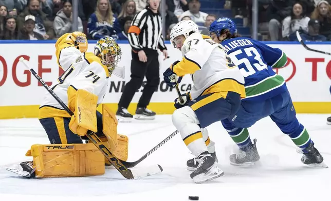 Nashville Predators goaltender Juuse Saros (74) stops Vancouver Canucks' Teddy Blueger (53) as Predators' Nick Blankenburg (37) looks on during the first period of an NHL hockey game in Vancouver, British Columbia, Friday, Jan. 3, 2025. (Ethan Cairns/The Canadian Press via AP)