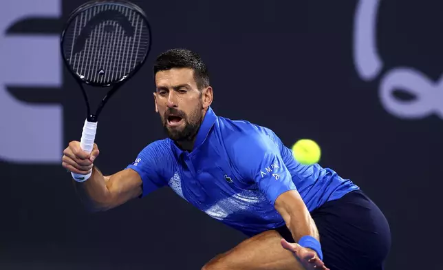 Serbia's Novak Djokovic returns a shot to USA's Reilly Opelka during their match at the Brisbane International, in Brisbane, Australia, Friday, Jan. 3, 2025. (AP Photo/Pat Hoelscher)