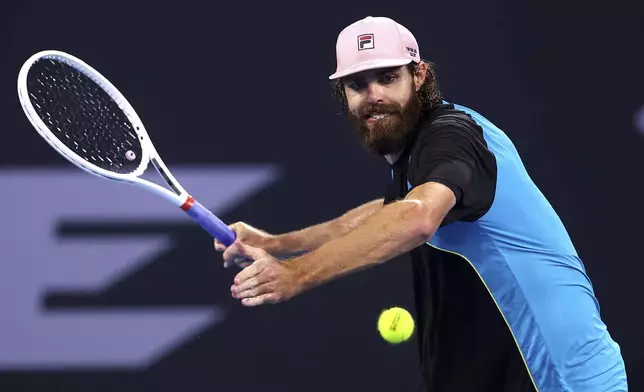 USA's Reilly Opelka plays a backhand to Serbia's Novak Djokovic during their match at the Brisbane International, in Brisbane, Australia, Friday, Jan. 3, 2025. (AP Photo/Pat Hoelscher)