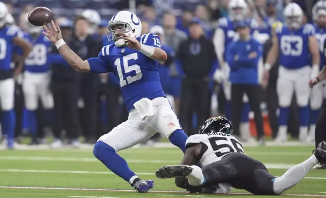 Indianapolis Colts quarterback Joe Flacco (15) throws an incomplete pass under pressure from Jacksonville Jaguars linebacker Yasir Abdullah (56) during the first half of an NFL football game, Sunday, Jan. 5, 2025, in Indianapolis. (AP Photo/Michael Conroy)