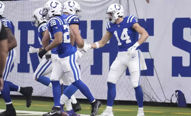 Indianapolis Colts wide receiver Alec Pierce (14) celebrates scoring a touchdown with guard Mark Glowinski (64) during the first half of an NFL football game, Sunday, Jan. 5, 2025, in Indianapolis. Also seen are Indianapolis Colts running back Jonathan Taylor (28) and tight end Kylen Granson (83). (AP Photo/Michael Conroy)