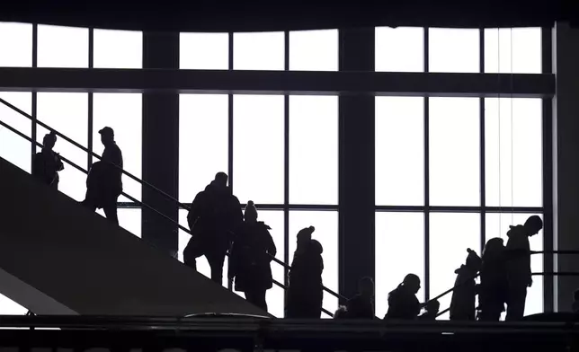 Fans make their way on escalators through Lucas Oil Stadium before an NFL football game between the Indianapolis Colts and the Jacksonville Jaguars, Sunday, Jan. 5, 2025, in Indianapolis. (AP Photo/Michael Conroy)