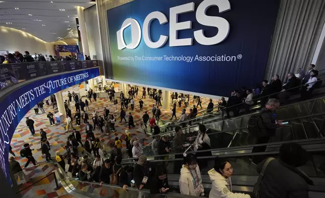 People attend the CES tech show Wednesday, Jan. 8, 2025, in Las Vegas. (AP Photo/John Locher)