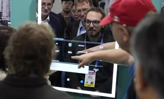 Attendees look at the FaceHeart CardioMirror, an AI-powered smart mirror for cardiac health assessments, during the CES tech show Wednesday, Jan. 8, 2025, in Las Vegas. (AP Photo/John Locher)