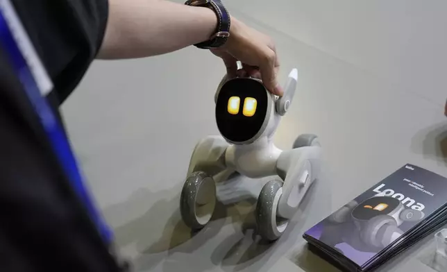 A person pets the Loona Petbot, a pet robot with facial recognition and Chat GPT, during the CES tech show Wednesday, Jan. 8, 2025, in Las Vegas. (AP Photo/John Locher)