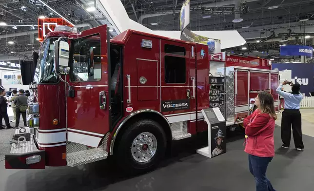 People look at a Pierce Volterra electric fire truck at the Oshkosh booth during the CES tech show, Tuesday, Jan. 7, 2025, in Las Vegas. (AP Photo/John Locher)