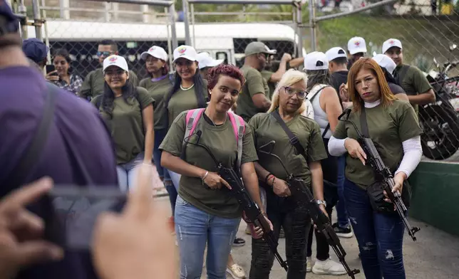 Members of government-backed militias pose with rifles prior to a march in Caracas, Venezuela, Tuesday, Jan. 7, 2025, days ahead of President Nicolas Maduro's inauguration for a third term. (AP Photo/Matias Delacroix)