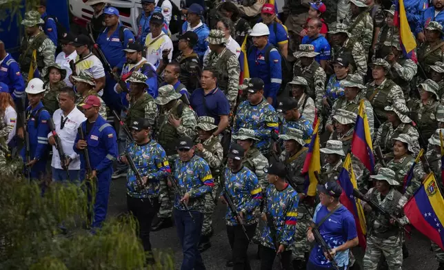 Government-backed militias pass through a street during a pro-government march in Caracas, Tuesday, Jan. 7, 2025, days ahead of President Nicolas Maduro's inauguration for a third term. (AP Photo/Matias Delacroix)