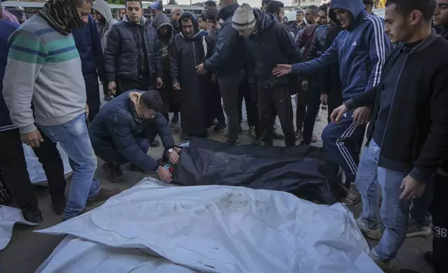 Mourners attend the funeral of three members of Hussein family who were killed in the Israeli bombardment in Maghazi, central Gaza Strip, at Al-Aqsa Martyrs Hospital in Deir al-Balah, Tuesday, Jan. 7, 2025. (AP Photo/Abdel Kareem Hana)