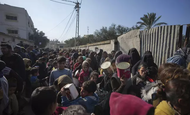 Palestinians queue for food in Deir al-Balah, Gaza Strip, Tuesday, Jan. 7, 2025. (AP Photo/Abdel Kareem Hana)