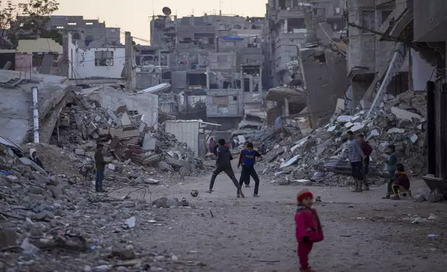 Palestinian children play next to buildings destroyed by Israeli army strikes in Khan Younis, Gaza Strip, Tuesday, Jan. 7, 2025. (AP Photo/Abdel Kareem Hana)