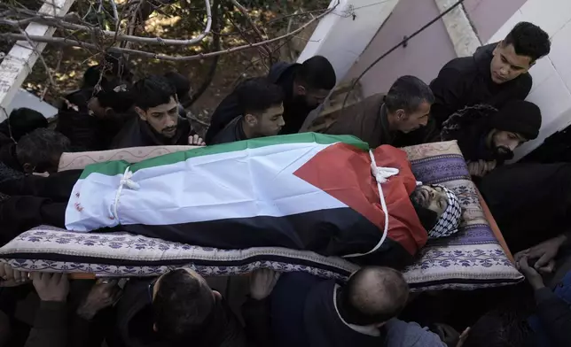 Mourners carry the body of Jaafar Dababsah, a Palestinian Hamas commander killed in a raid by Israeli forces, during his funeral in the village of Talouza, near the West Bank city of Nablus, Tuesday, Jan. 7, 2025. (AP Photo/Majdi Mohammed)