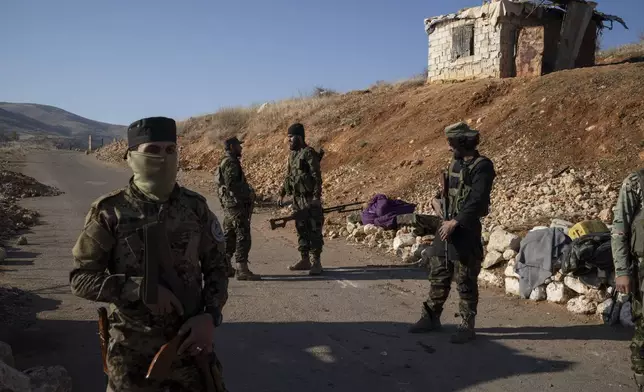 Members of the new security forces stand guard at a checkpoint located near the border with Lebanon, in the town of Serghaya, Syria, Tuesday, Jan. 7, 2025. (AP Photo/Leo Correa)