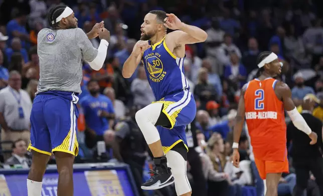 FILE - Golden State Warriors guards Buddy Hield, left, and Stephen Curry (30) celebrate as Oklahoma City Thunder guard Shai Gilgeous-Alexander (2) leaves the court during the second half of an NBA basketball game Nov. 10, 2024, in Oklahoma City. (AP Photo/Nate Billings, File)