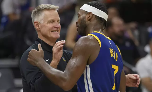 FILE - Golden State Warriors head coach Steve Kerr, left, greets Warriors guard Buddy Hield who comes off the court during the second half of a preseason NBA basketball game against the Sacramento Kings in Sacramento, Calif., Oct. 9, 2024. (AP Photo/Randall Benton, File)