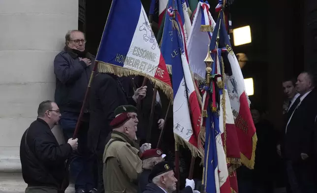 Veterans hold flags at the entrance of Notre Dame du Val-de-Grace church during a public memorial for late far-right leader Jean-Marie Le Pen, Thursday, Jan. 16, 2025 in Paris. Jean-Marie Le Pen, the founder of France's main far-right party, died on Jan.7, 2025 aged 96. (AP Photo/Michel Euler)