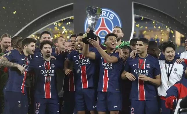 PSG players celebrate with a trophy after the French Super Cup final match between Paris Saint Germain and Monaco in Doha, Qatar, on Sunday, Jan. 5, 2025.(AP Photo/Hussein Sayed)