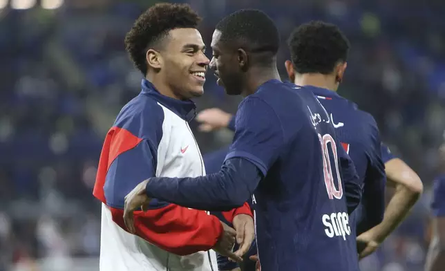 PSG's Desire Doue, left, hugs Ousmane Dembele after he scored the winner during the French Super Cup final match between Paris Saint Germain and Monaco in Doha, Qatar, on Sunday, Jan. 5, 2025.(AP Photo/Hussein Sayed)