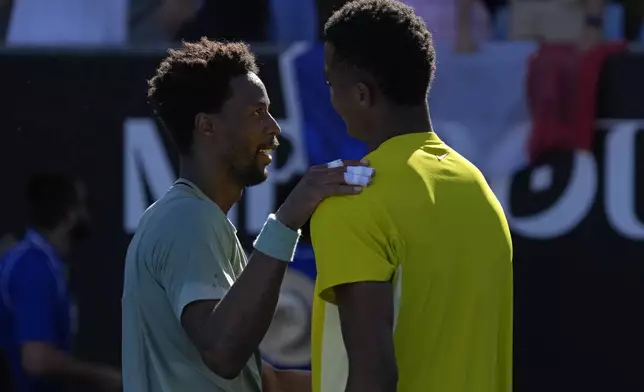 Gael Monfils, left, of France is congratulated by compatriot Giovanni Mpetshi Perricard following their first round match at the Australian Open tennis championship in Melbourne, Australia, Tuesday, Jan. 14, 2025. (AP Photo/Manish Swarup)