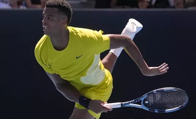 Giovanni Mpetshi Perricard of France serves to compatriot Gael Monfils during their first round match at the Australian Open tennis championship in Melbourne, Australia, Tuesday, Jan. 14, 2025. (AP Photo/Asanka Brendon Ratnayake)