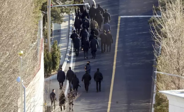 Investigators from the Corruption Investigation Office for High-ranking Officials walk up a slope inside the premises of impeached President Yoon Suk Yeol's residence in Seoul, South Korea, Friday, Jan. 3, 2025. (Lee Jin-wook/Yonhap via AP)