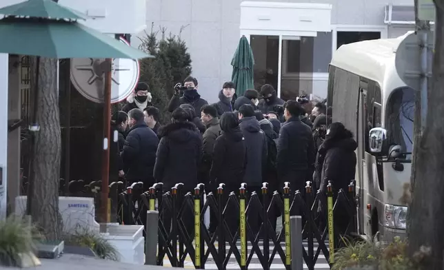 Investigators from the Corruption Investigation Office for High-ranking Officials arrive at the gate of the presidential residence as supporters of impeached South Korean President Yoon Suk Yeol stage a rally to oppose a court having issued a warrant to detain Yoon, in Seoul, South Korea, Friday, Jan. 3, 2025. (AP Photo/Lee Jin-man)