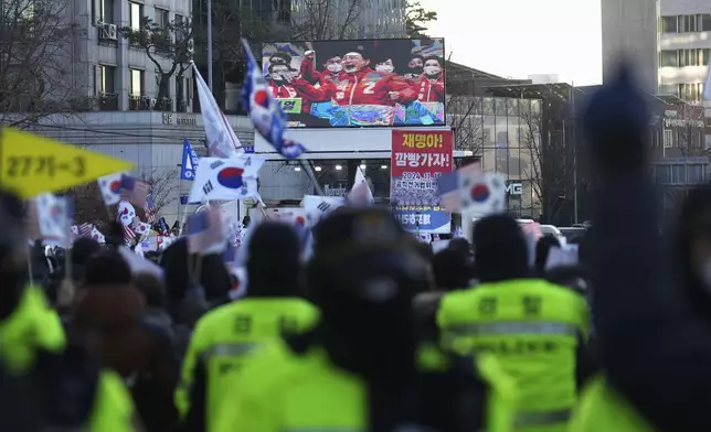 A huge screen showing a file footage of South Korean President Yoon Suk Yeol as supporters of impeached South Korean President Yoon Suk Yeol stage a rally to oppose a court having issued a warrant to detain Yoon, near the presidential residence in Seoul, South Korea, Friday, Jan. 3, 2025. The letters read, "Oppose Impeachment." (AP Photo/Lee Jin-man)