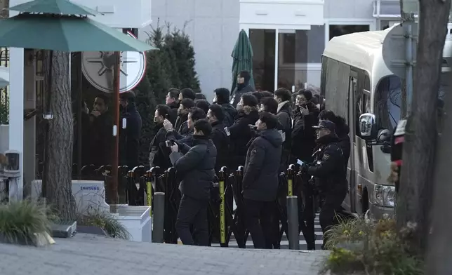 Police officers arrive at the gate of the presidential residence as supporters of impeached South Korean President Yoon Suk Yeol stage a rally to oppose a court having issued a warrant to detain Yoon, in Seoul, South Korea, Friday, Jan. 3, 2025. (AP Photo/Lee Jin-man)