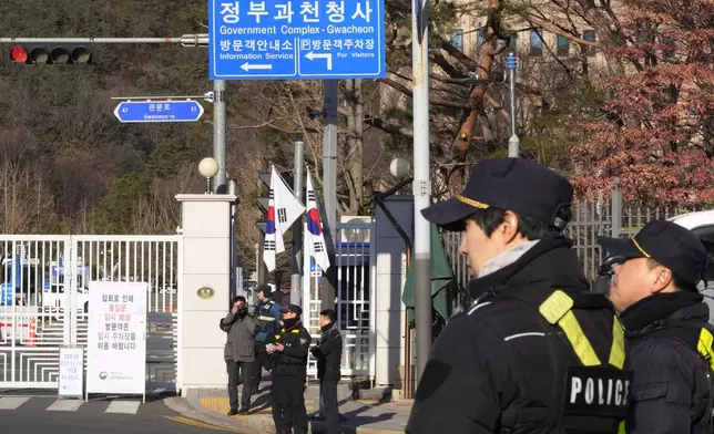 Police officers stand guard as they wait for the arrival of impeached South Korean President Yoon Suk Yeol near the Corruption Investigation Office for High-ranking Officials in Gwacheon, South Korea, Friday, Jan. 3, 2025. (AP Photo/Ahn Young-joon)